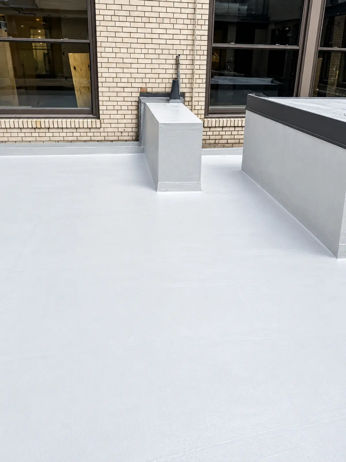 Completed white waterproofing across the courtyard walkway